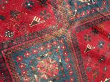 a close up of a red rug with many different designs on it