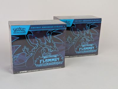 deux boîtes de figurines Pokémon posées sur une surface blanche