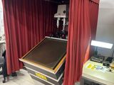 une image représentant une pièce avec un rideau rouge et une machine
