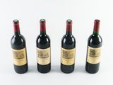 three bottles of wine are lined up in a row on a white surface