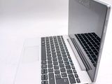 a white laptop with a black keyboard on a white surface
