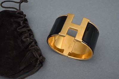 black and gold cuff bracelet with a black velvet bag and a black velvet pouch