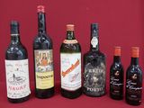 several bottles of wine are lined up on a red surface