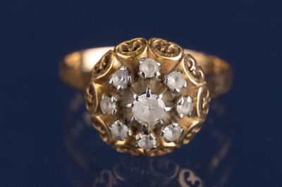 une bague en or sertie d'un diamant, posée sur un fond bleu