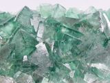 some pieces of green glass sitting on top of a white surface