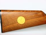 a close up of a rifle with a gold coin on it