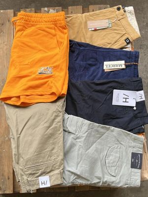 trois paires de shorts pour homme posées sur une caisse en bois