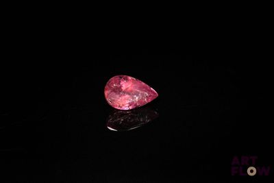 gros plan d'un diamant rose sur une surface noire