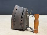 a small metal object with a wooden handle on a table