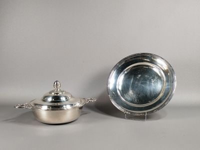 un plateau en argent avec un couvercle et un bol en argent posé sur une table