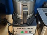 un mixeur posé sur une table à côté d'un ordinateur portable