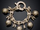 a close up of a silver bracelet with charms on a black background