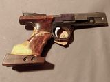 un pistolet posé sur une table avec un morceau de bois