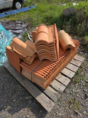 une pile de briques d'argile posée sur une palette à côté d'un camion