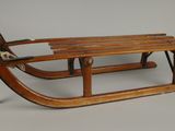 une vieille luge en bois à laquelle est attachée une corde