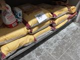Plusieurs sacs de riz sont empilés sur une étagère dans un magasin.