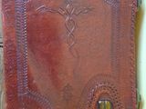 an old leather book sitting on top of a wooden table