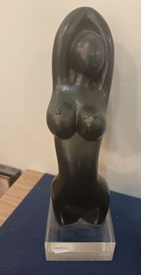 statue of a woman holding a baby in her arms on a blue table