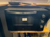 a black oven sitting on top of a wooden counter