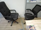 two black office chairs sitting next to each other on the floor