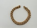 a close up of a gold bracelet on a white surface