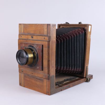 an old wooden camera with a lens attached to it