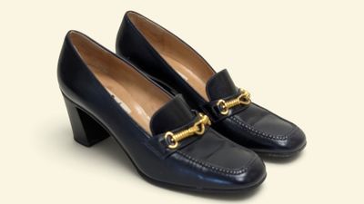 un gros plan sur une paire de chaussures noires ornées d'une chaîne dorée