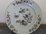 a plate with a design of flowers and birds on it