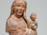 an old wooden statue of a woman holding a child