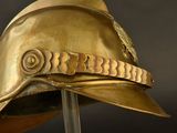 a gold helmet on a stand with a black background