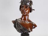 un buste en bronze représentant une femme coiffée d'un chapeau