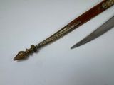 two knives are sitting on a white surface with a wooden handle
