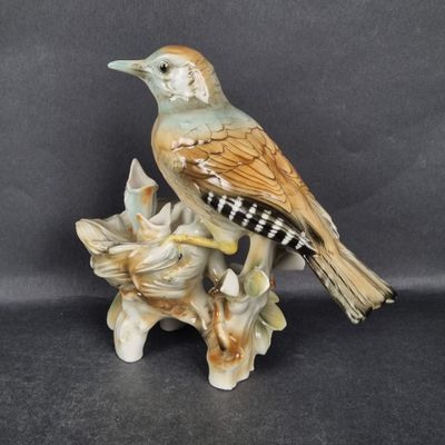 a figurine of a bird sitting on a branch