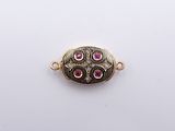 a close up of a gold plated pendant with pink stones