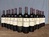 several bottles of wine are lined up on a wooden table