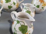 four white pitchers with yellow and green flowers on them