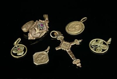 plusieurs breloques et pendentifs en or et en argent sur un fond noir