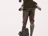 bronze statue of a woman holding a dog on a wooden base