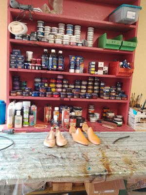 une table sur laquelle il y a un peu de peinture et une paire de chaussures posée dessus
