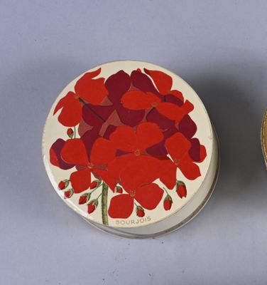 two tins with red flowers on them sitting next to each other