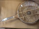 a metal strainer sitting on top of a cardboard box