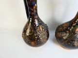 two vases that are sitting on a table