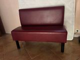 banquette en cuir bordeaux avec des pieds noirs