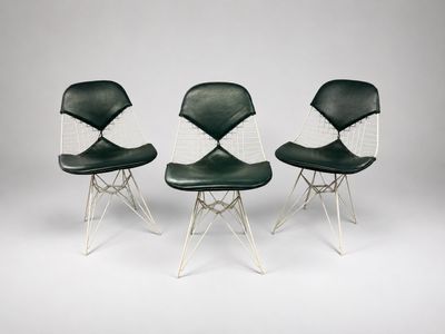 three black and white chairs sitting next to each other on a white surface