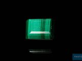 a close up of a green square stone on a black surface
