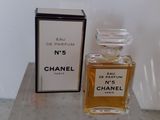 un flacon de parfum Chanel n° 5 et son coffret posés sur une table en marbre