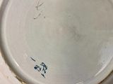 a white plate with blue writing on it sitting on a table