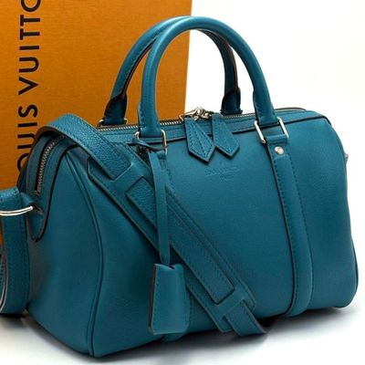 tiffany blue leather handbag next to a box of louis vuittois