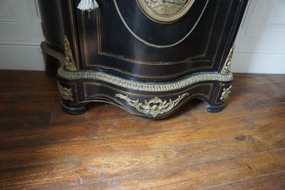 un meuble noir et doré surmonté d'une horloge