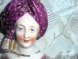 une figurine représentant une femme coiffée d'un turban violet